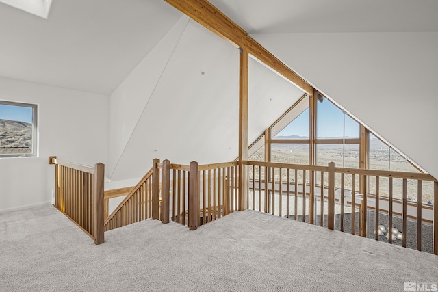 additional living space featuring lofted ceiling with skylight, a water view, carpet, and plenty of natural light