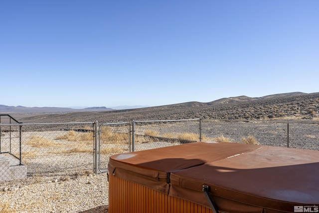 view of yard featuring a rural view, a hot tub, and a mountain view