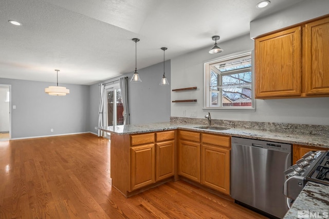 kitchen with decorative light fixtures, sink, stainless steel dishwasher, and kitchen peninsula