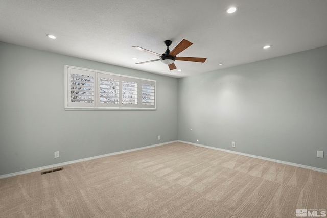 empty room featuring ceiling fan and light colored carpet