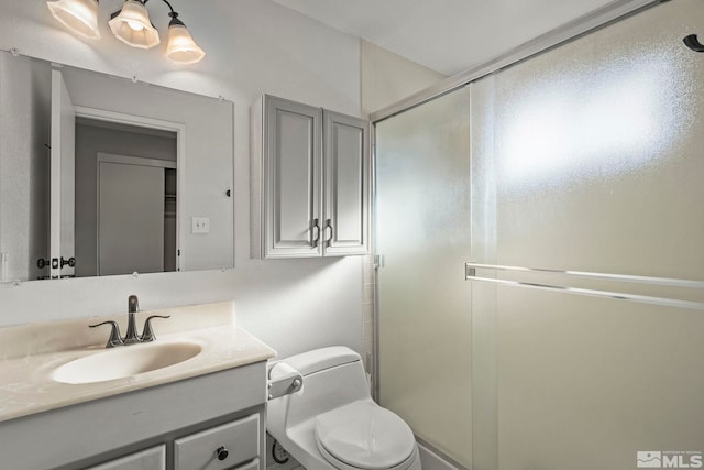 bathroom featuring an enclosed shower, vanity, and toilet