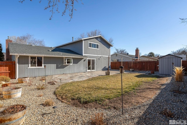 rear view of house with a lawn, a storage shed, and a patio