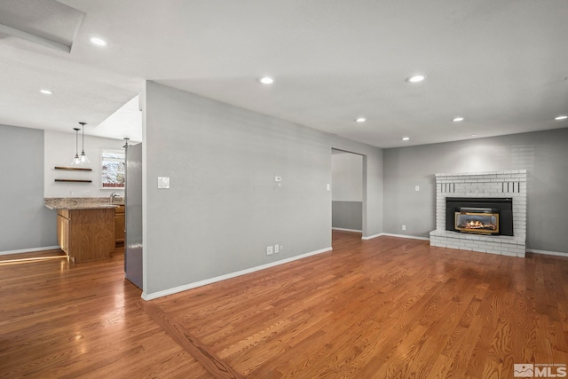 unfurnished living room with a fireplace and hardwood / wood-style flooring