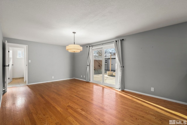 empty room featuring a textured ceiling and hardwood / wood-style flooring