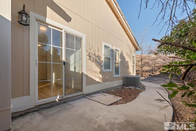 view of side of property with a patio and cooling unit