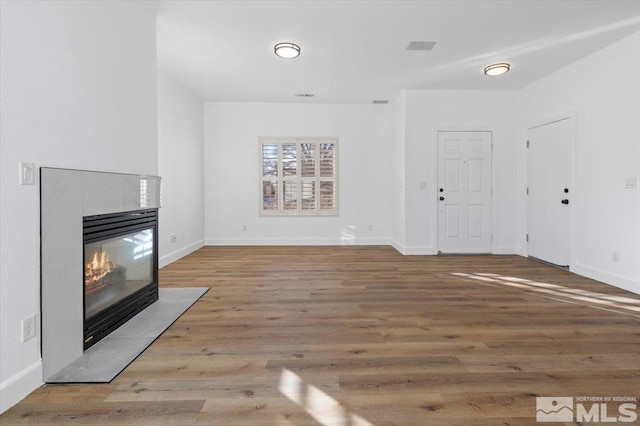 unfurnished living room with a fireplace and light wood-type flooring