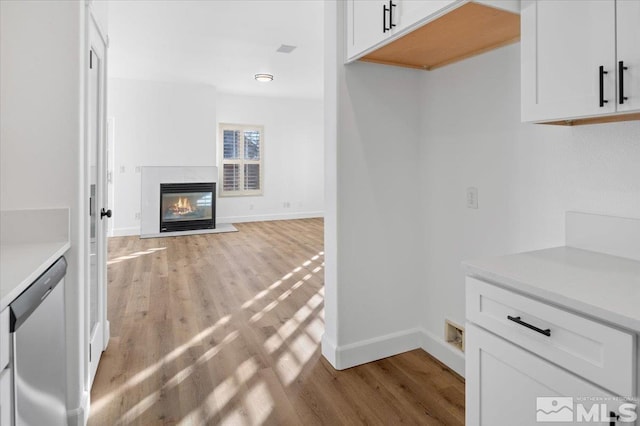 kitchen with dishwasher, light hardwood / wood-style floors, and white cabinetry