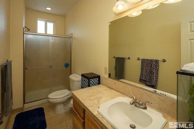 bathroom featuring toilet, walk in shower, and vanity