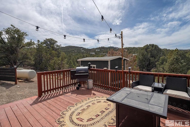 deck with an outbuilding, a mountain view, and grilling area