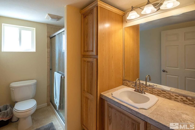 bathroom with toilet, an enclosed shower, and vanity