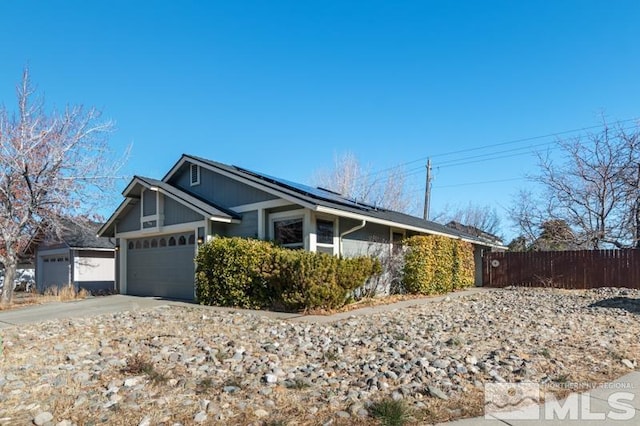 view of side of home featuring solar panels and a garage