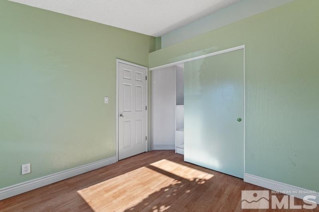 unfurnished bedroom with hardwood / wood-style floors