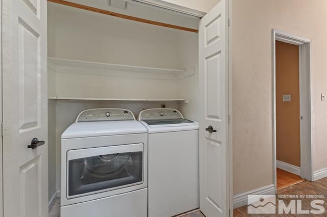 clothes washing area featuring separate washer and dryer and light hardwood / wood-style flooring