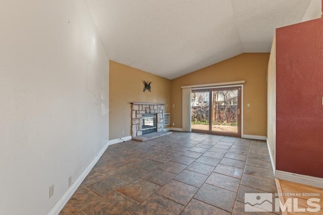 unfurnished living room with lofted ceiling, a fireplace, and a textured ceiling