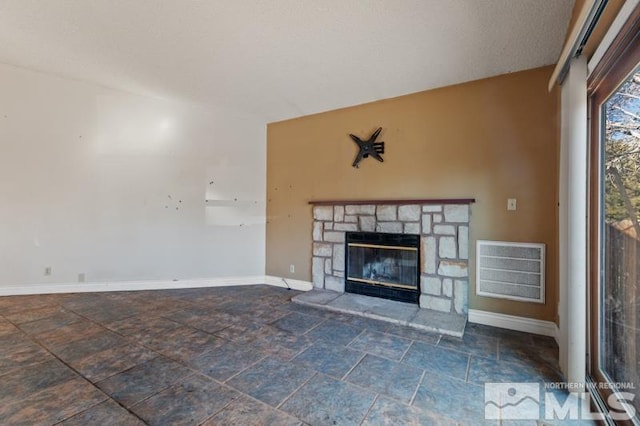 unfurnished living room featuring a stone fireplace