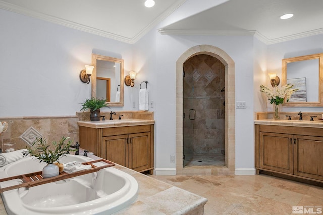 bathroom with ornamental molding, vanity, and shower with separate bathtub