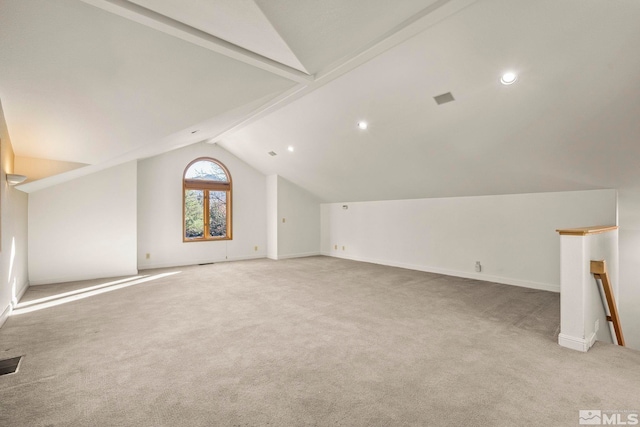 additional living space with vaulted ceiling with beams and light colored carpet