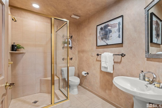 bathroom featuring toilet, tile patterned flooring, sink, and walk in shower