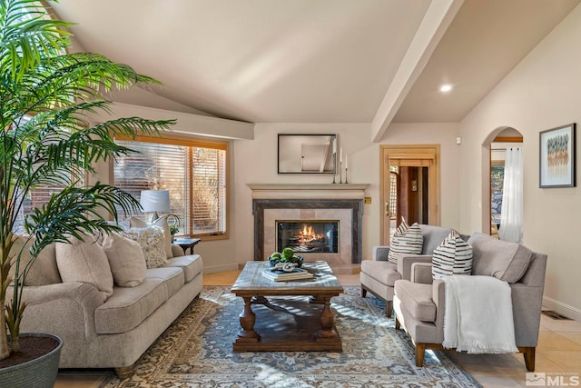 living room featuring lofted ceiling with beams and a high end fireplace