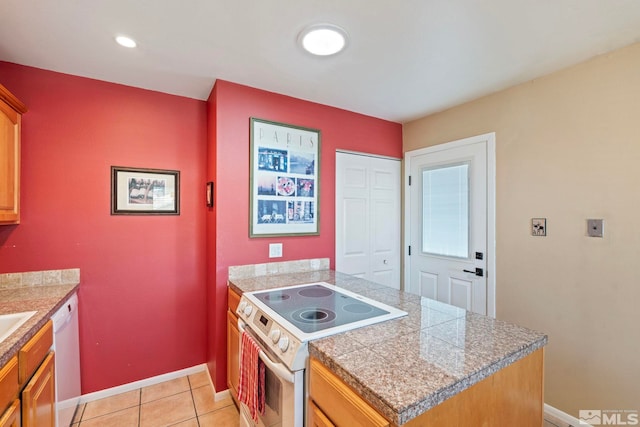 kitchen featuring white appliances, a kitchen island, and light tile patterned flooring