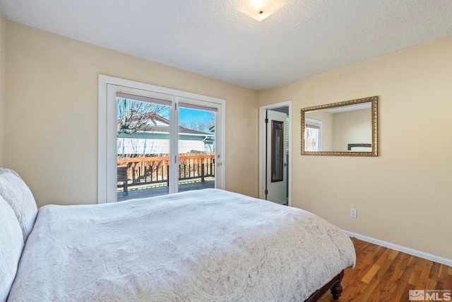 bedroom featuring a textured ceiling, dark hardwood / wood-style flooring, and access to exterior