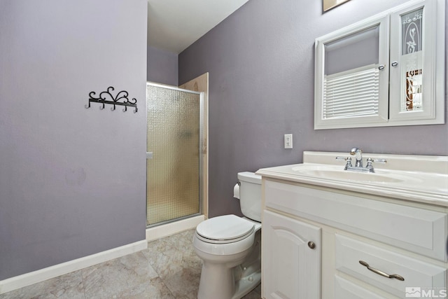 bathroom featuring toilet, vanity, and a shower with shower door