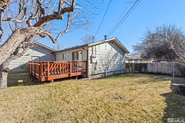 back of property with a deck and a lawn