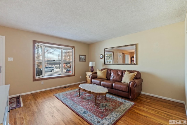 living room featuring a textured ceiling and light hardwood / wood-style floors