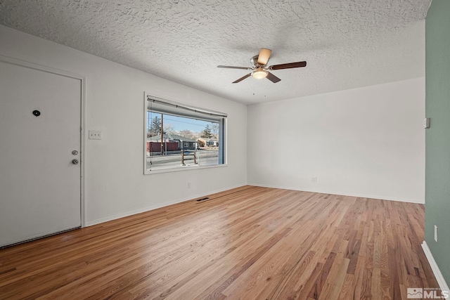 spare room with a textured ceiling, ceiling fan, and hardwood / wood-style flooring