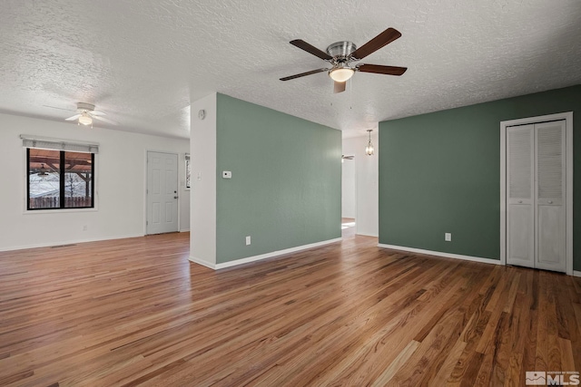 unfurnished room featuring a textured ceiling, hardwood / wood-style floors, and ceiling fan