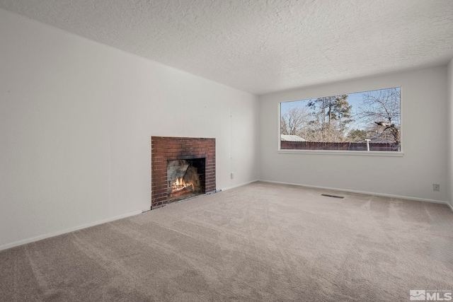 unfurnished living room featuring carpet flooring, a fireplace, and a textured ceiling