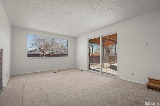 carpeted empty room with a textured ceiling