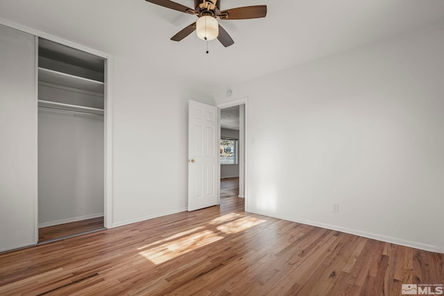 unfurnished bedroom featuring a closet, ceiling fan, and light wood-type flooring