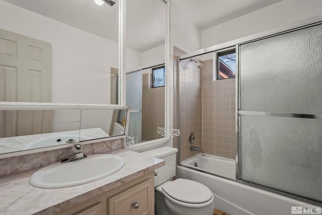 full bathroom featuring toilet, vanity, and combined bath / shower with glass door