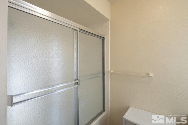 bathroom with shower / bath combination with glass door