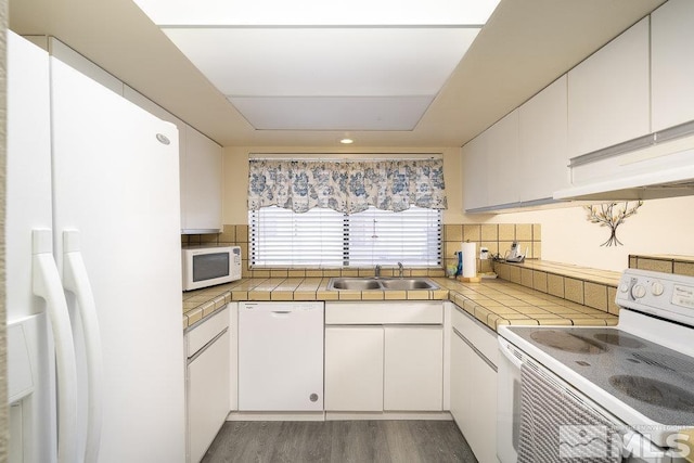 kitchen with white appliances, tile countertops, dark hardwood / wood-style flooring, white cabinetry, and sink