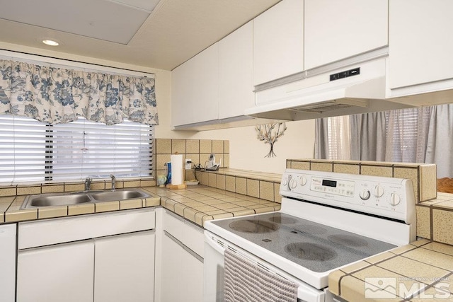 kitchen with white appliances, sink, tile countertops, and white cabinetry