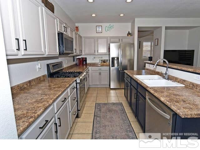 kitchen featuring stainless steel appliances, gray cabinets, light tile patterned floors, and sink