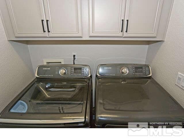 clothes washing area featuring cabinets and independent washer and dryer