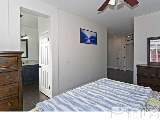 bedroom with ceiling fan, dark hardwood / wood-style flooring, and connected bathroom