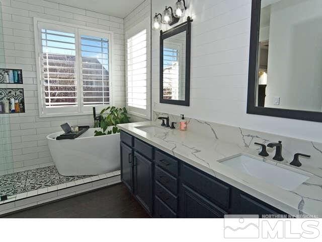 bathroom with vanity and a bath