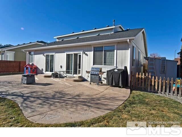 rear view of property featuring a patio area and a lawn