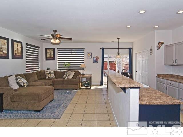 tiled living room with ceiling fan and a wealth of natural light