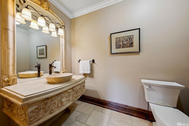 bathroom featuring toilet, crown molding, and sink