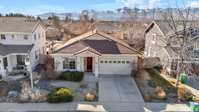 front of property with a garage and a mountain view