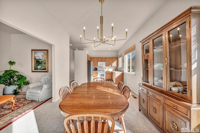 carpeted dining space featuring an inviting chandelier