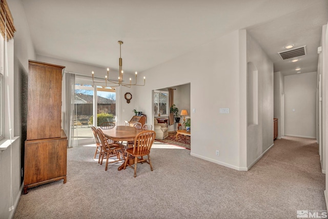 carpeted dining room featuring a chandelier