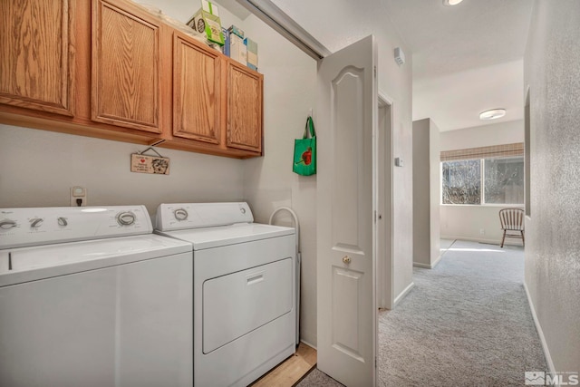 washroom featuring light carpet, separate washer and dryer, and cabinets