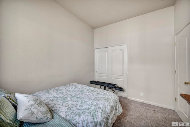 carpeted bedroom with a closet and lofted ceiling