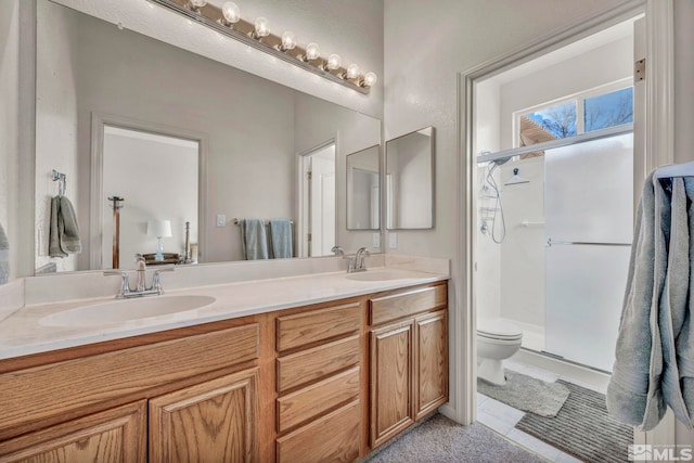 bathroom with toilet, a shower with door, and vanity